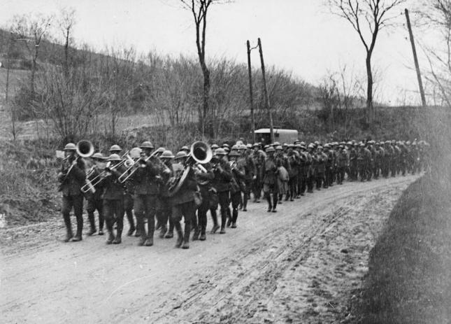 12th Battalion, London Regiment (The Rangers) of the 58th London Division re-entering a village on returning from the lines, headed by their band. Villers-Cotterets, Aisne. [© IWM (Q 47601)]